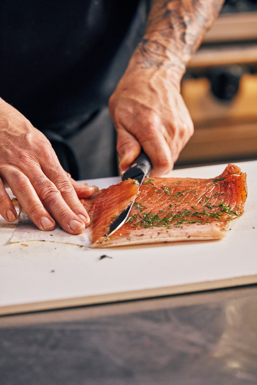 Cocinero cortando gravlax en la cocina del Club Sueco